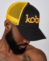KOBO Suede Trucker Hat: Midnight Black & Palm Gold
